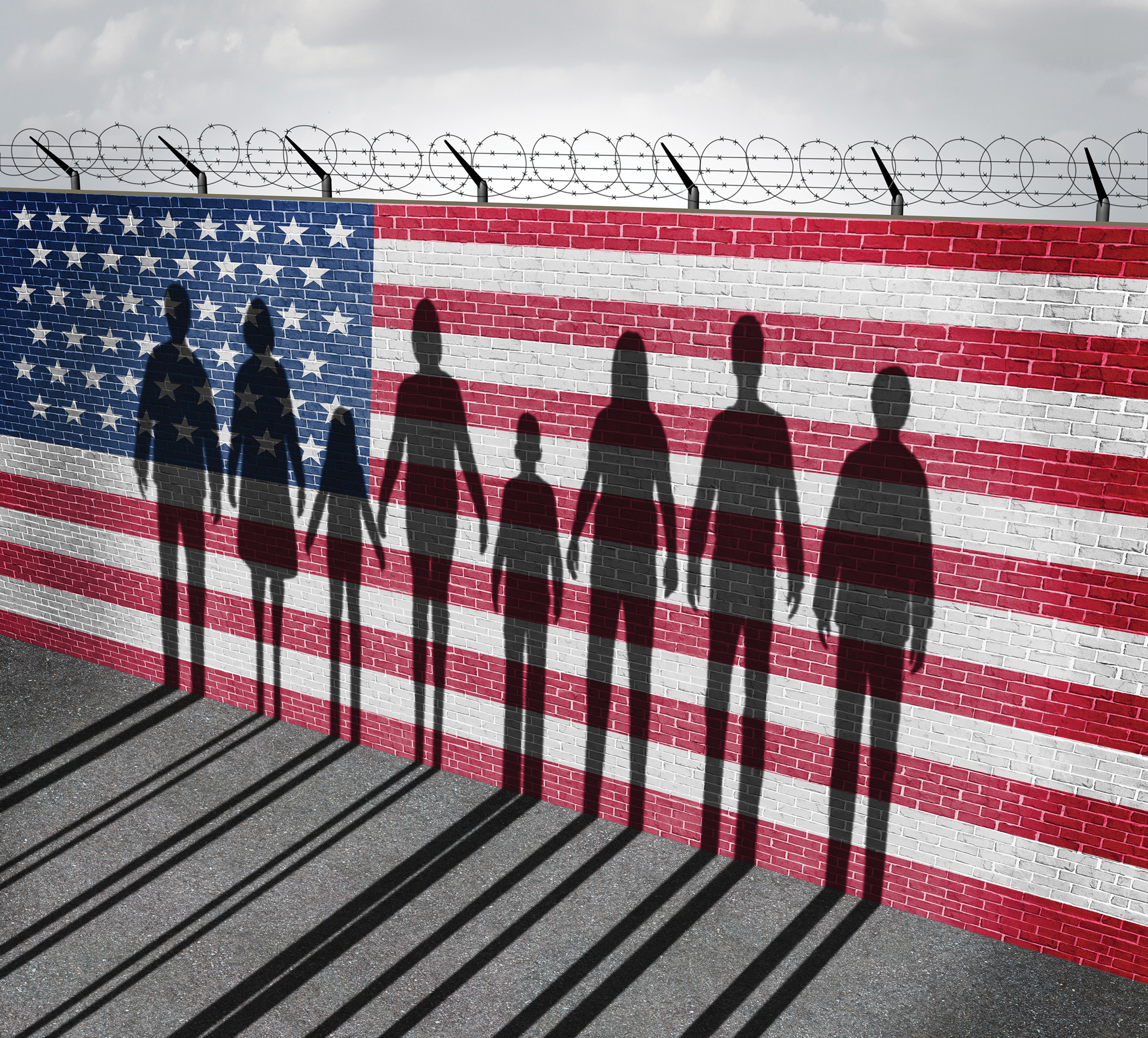 Human silhouettes on a barb wired fence covered with the American flag
