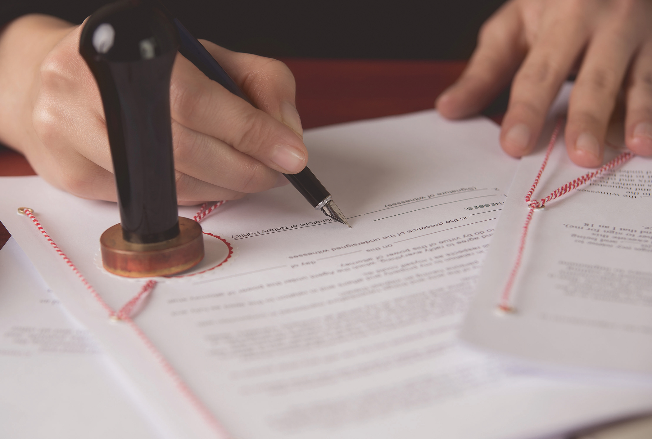 Close up on a notary public hand signing a document