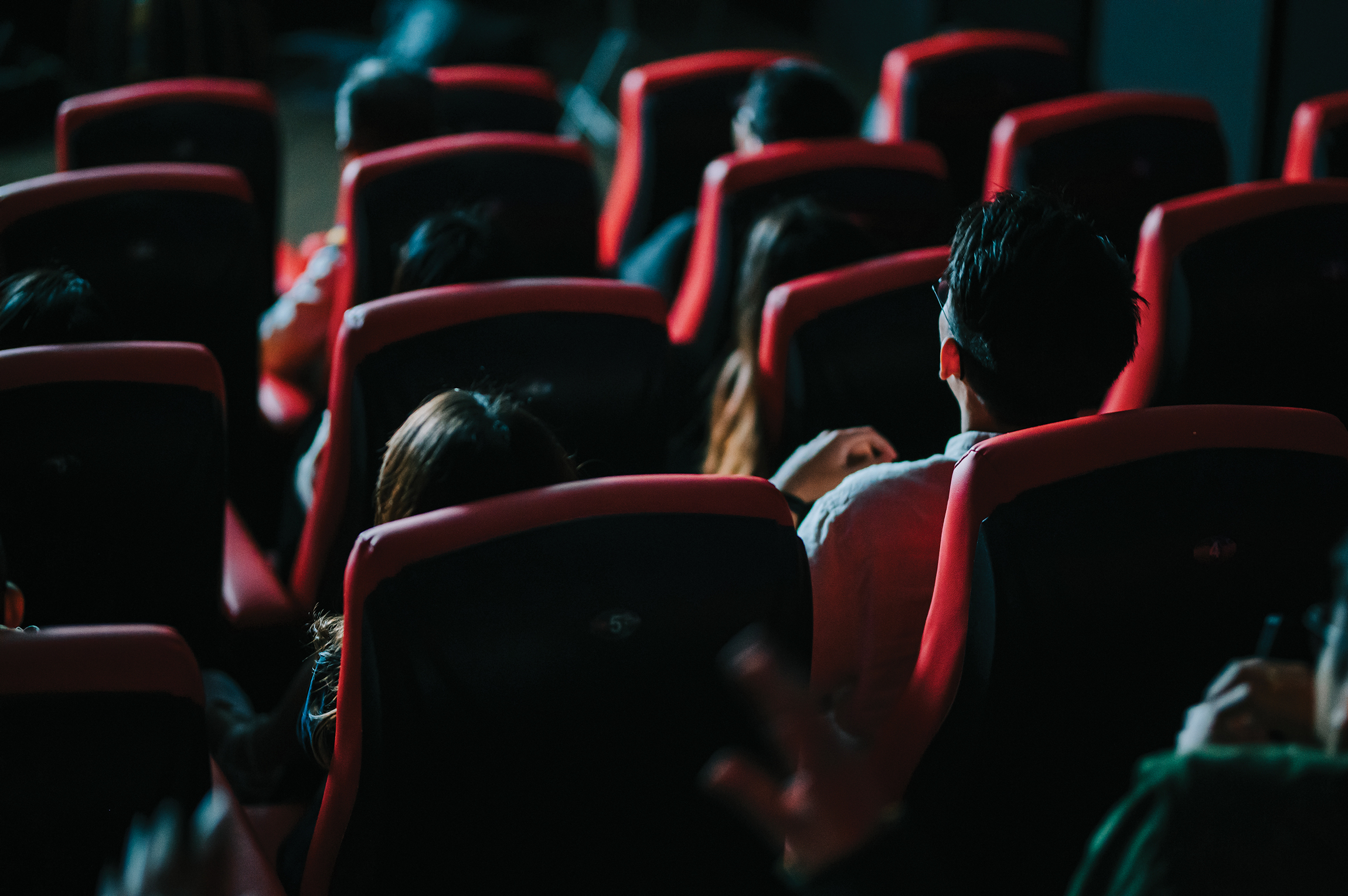 Rear view of audience watching 3D movie in a theater