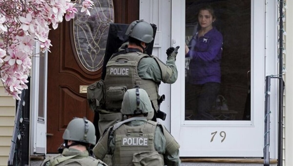 Woman opening door to an armed SWAT team
