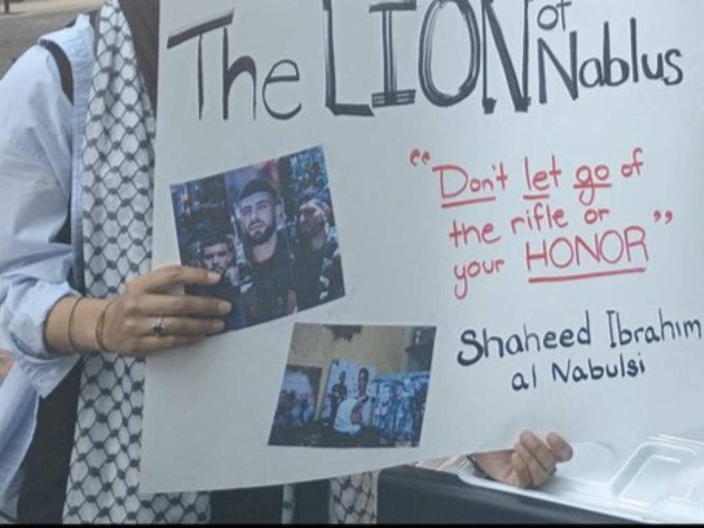 Person holding sign "The Lion of Nablus"