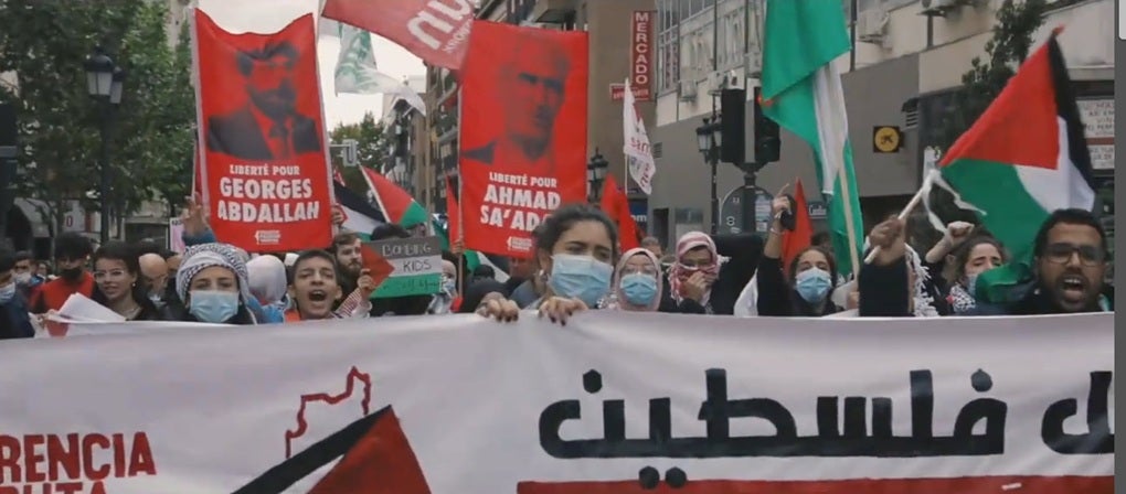 Protesters march with posters in support of Georges Abdallah and Ahmad Sa’adat, PFLP members, at a Masar Badil rally in 2021