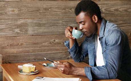 Black Man Reading Tablet in Cafe
