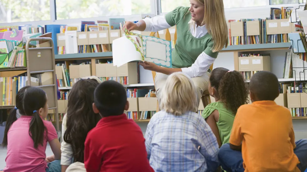 Teacher in Class Reading to Students
