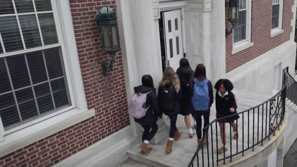 Students walking in and out of a school's front door