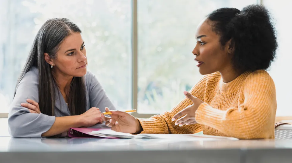 Middle school student talking with teacher