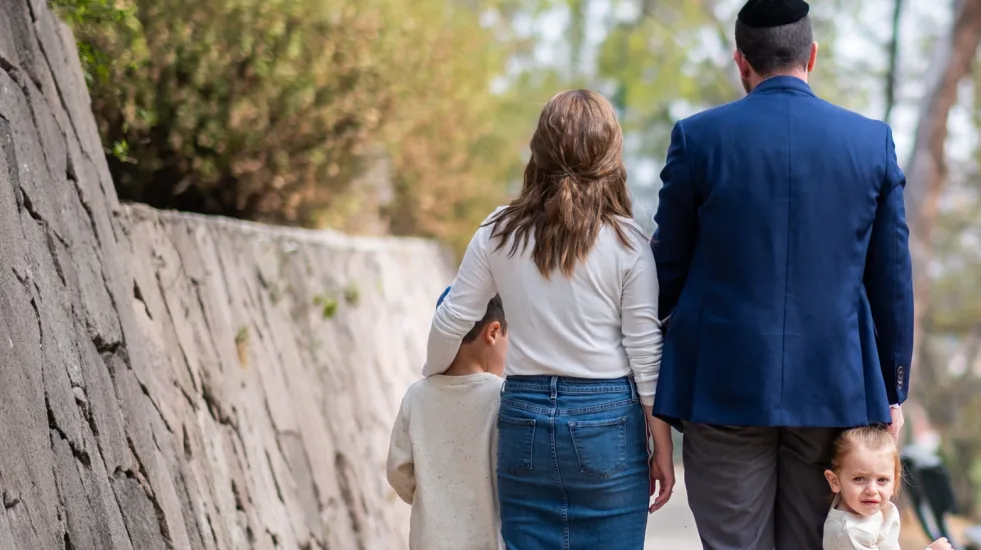 Rear view of a young Jewish family walking in a park
