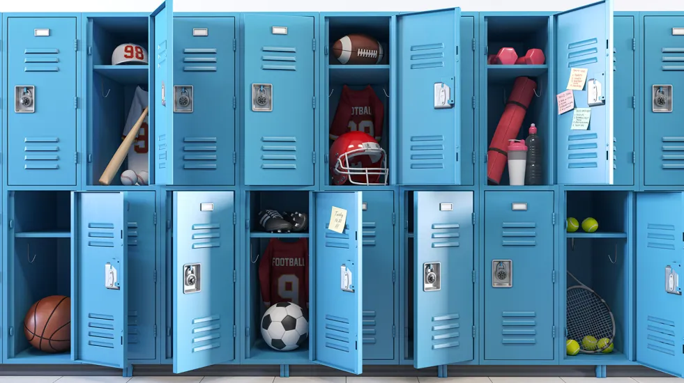Open lockers at school with various sports equipment and materials inside