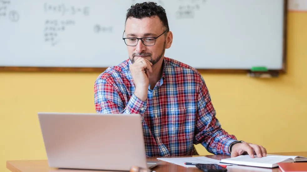 Teacher working at his desk in a classroom