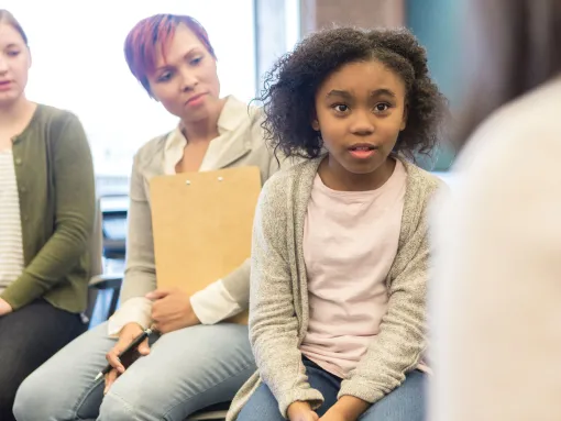 Concerned little girl discusses problems with after school group with adults