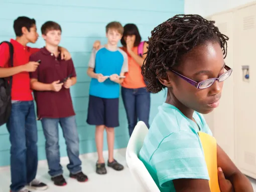 Preteen students using technology to cyber bully an African American female classmate