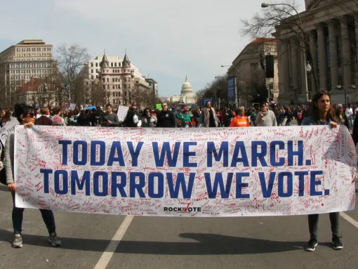 People holding a "Today We March, Tomorrow We Vote" banner during March for Our Lives rally in DC