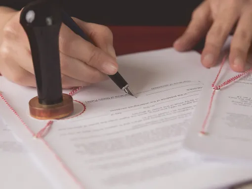 Close up on a notary public hand signing a document