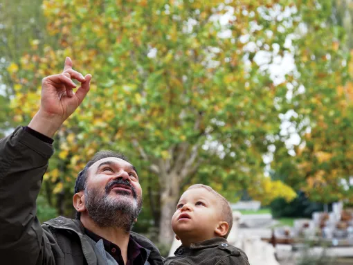 Jewish grandfather holding child and point to the sky