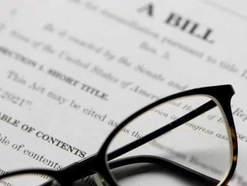Eyeglasses laying on top of a bill legislation