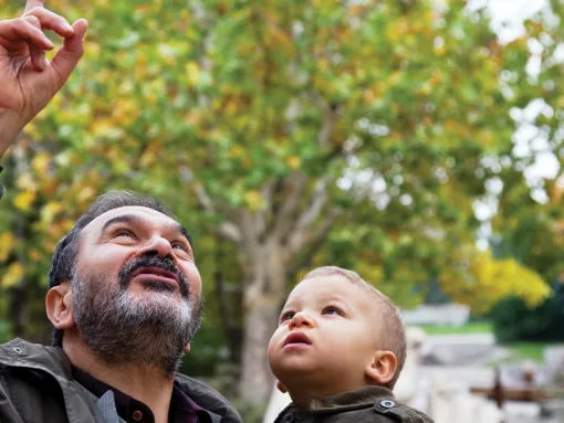 Jewish grandfather holding child and point to the sky