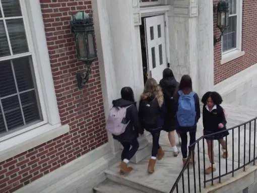 Students walking in and out of a school's front door