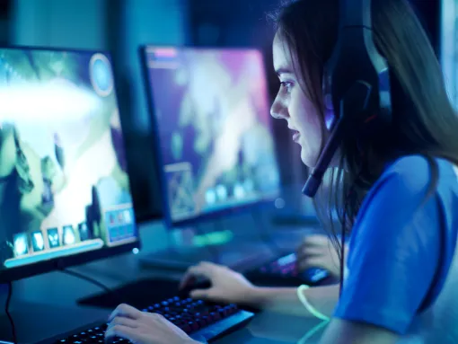 Professional girl gamer plays video game on her computer