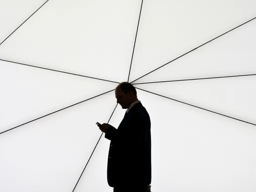 Individual looking at phone in silhouette