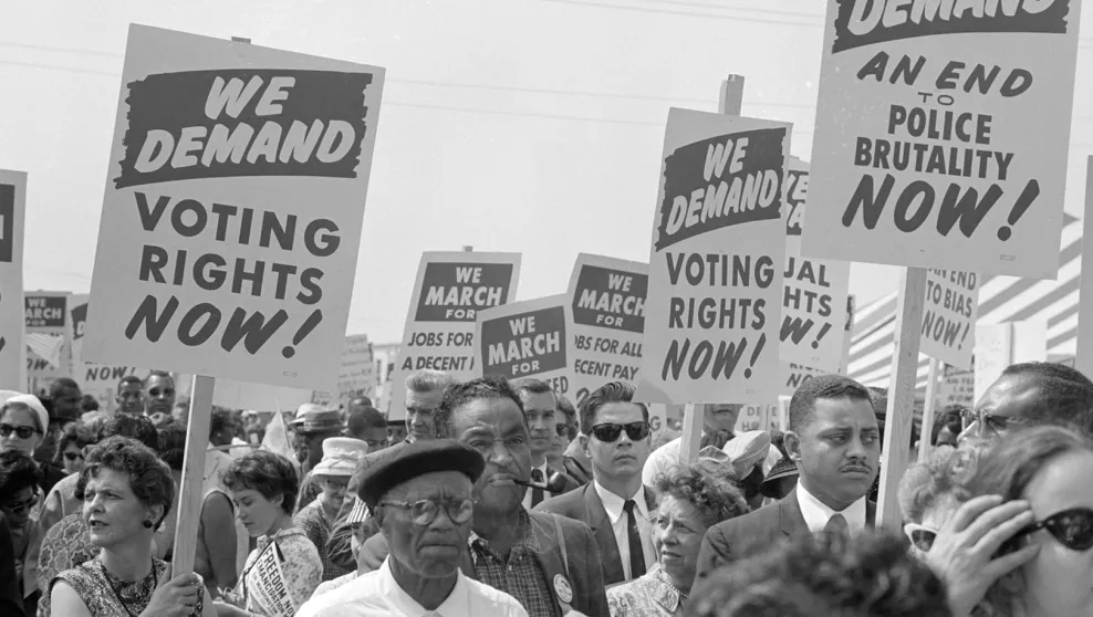 Demonstrators with signs march for voting rights, jobs, an end to police brutality at the March on Washington, 1963