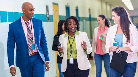 Teachers talking while walking down a hallway