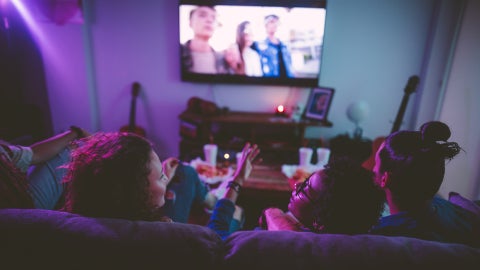 Teens watching TV together